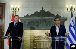 FILE - Greece's Prime Minister Alexis Tsipras, right, talks during a joint news conference with Turkey's President Recep Tayyip Erdogan at Maximos Mansion in Athens, Dec. 7, 2017.