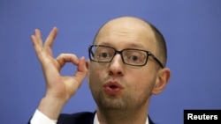 FILE - Ukrainian Prime Minister Arseny Yatseniuk gestures at a news conference in Kyiv, in this file picture taken December 30, 2014. 