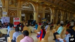 FILE - Candidates wait to attend interviews during a job fair conducted by Hyderabad city police in Hyderabad, India, July 24, 2021.