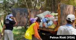 Petugas menaikkan sampah plastik dan popok ke atas bak truk di kawasan Wringinanom, Gresik (Foto: VOA/ Petrus Riski).