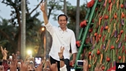 In this file photo, Indonesian president-elect Joko Widodo greets supporters during a gathering in Jakarta, Wednesday, July 23, 2014. 