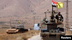 Hezbollah and Syrian flags flutter on a military vehicle in Western Qalamoun, Syria, Aug, 28, 2017.