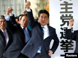 Japan's Prime Minister Shinzo Abe (3rd L) and his party's lawmakers raise their fists as they pledge to win in the upcoming lower house election, at their party headquarters in Tokyo, Japan September 28, 2017.