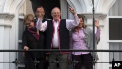 Flanked by his running mates Mercedes Araoz, right, and Martin Vizcarra, presidential candidate Pedro Pablo Kuczynski acknowledges supporters and reporters gathered outside his home in Lima, Peru, Monday, June 6, 2016.