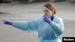 Una doctora ayuda a dar marcha atrás a una ambulancia en el Life Care Center de Kirkland, el centro de atención a largo plazo vinculado a varios casos confirmados de coronavirus en el estado, en Kirkland, Washington, EE. UU., 7 de marzo de 2020.