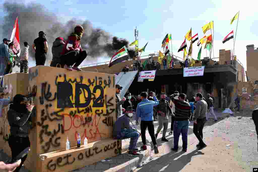 Pro-Iranian militiamen and their supporters set a fire during a sit-in in front of the U.S. embassy in Baghdad, Iraq. U.S. troops fired tear gas to disperse pro-Iran protesters who were gathered outside the embassy compound for a second day.