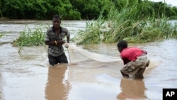 FILE - Children work to salvage goods washed away by floodwaters in the southern district of Chikwawa, near Blantyre, Malawi, Jan, 15, 2015. 