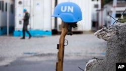 This Feb. 22, 2017 photo shows a U.N. peacekeeper's blue helmet balanced on a weapon in Port-au-Prince, Haiti.