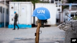 This Feb. 22, 2017 photo shows a U.N. peacekeeper's blue helmet balanced on a weapon in Port-au-Prince, Haiti.