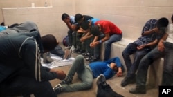 Immigrants, who have been caught crossing the border illegally, are housed inside the McAllen Border Patrol Station in McAllen, Texas where they are processed, July 15, 2014. 