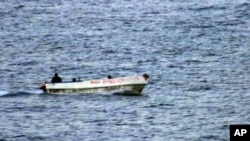 An armed suspected pirate looks over the edge of a skiff, in international waters off the coast of Somalia (2006 file photo)