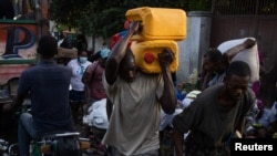 A man carries containers used for oil and gasoline during fuel shortages in Port-au-Prince, Haiti October 30, 2021. Picture taken on October 30, 2021. 
