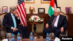 FILE - U.S. Secretary of State John Kerry (L), meets with Palestinian President Mahmoud Abbas, at the Palestinian Ambassador's Residence in Amman, Jordan, March 26, 2014.