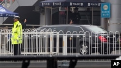 A limousine without car plates and bearing a gold color emblem on its side arrives amid heavy security at the train station in Beijing, March 27, 2018.