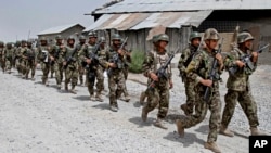 Afghan National Army soldiers march in Sangin district of Kandahar province southern Afghanistan, June 13, 2013.