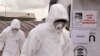 FILE - Health workers wearing Ebola protective gear work at an Ebola treatment center at Tubmanburg on the outskirts of Monrovia, Liberia, Nov. 28, 2014.