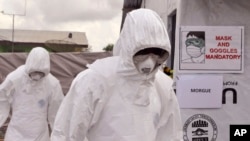 FILE - Health workers wearing Ebola protective gear work at an Ebola treatment center at Tubmanburg on the outskirts of Monrovia, Liberia, Nov. 28, 2014.