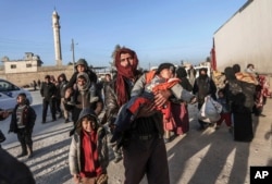 FILE - Syrians gather at the Bab al-Salam border gate with Turkey, in Syria, Feb. 6, 2016.