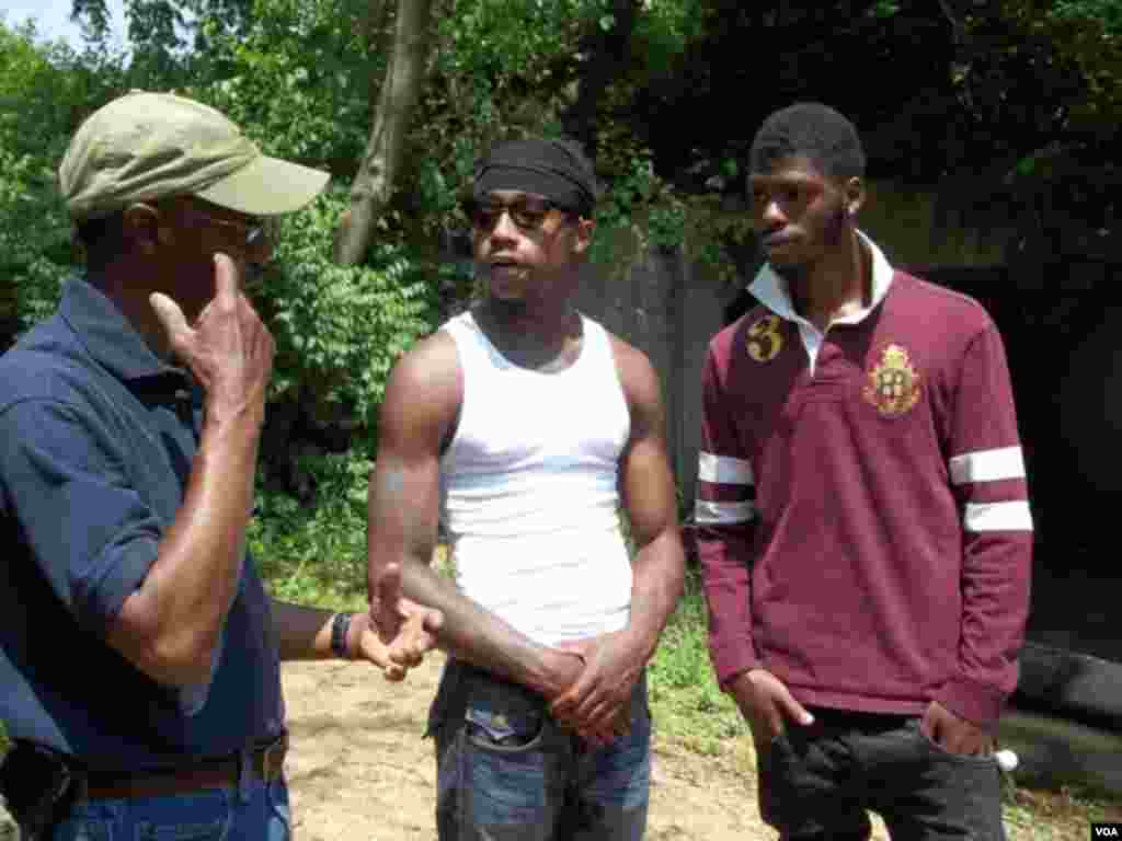 Direktur Groundwork Anacostia River Dennis Chestnut berbicara dengan warga Trevon Brox dan Antony Smith mengenai pekerjaan-pekerjaan di sungai tersebut. (VOA/Rosanne Skirble)