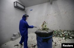 Pelajar SMA Qiu Siyu menggunakan baju pelindung saat memecahkan botol-botol anggur di rumah marah di Beijing, China, 12 Januari 2019.