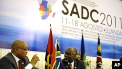 South African President Jacob Zuma (L) speaks with SADC Executive Secretary Tomaz Salomao (R) at the closing ceremony of the 31st SADC summit in Luanda, Angola, August 18, 2011