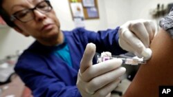 Ana Martinez, seorang asisten medis di Sea Mar Community Health Center, memberi suntikan flu kepada seorang pasien, Kamis, 11 Januari 2018 di Seattle (foto: AP Photo/Ted S. Warren)