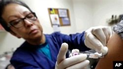 Ana Martinez, a medical assistant at the Sea Mar Community Health Center, gives a patient a flu shot, Jan. 11, 2018, in Seattle. According to an update by the Centers for Disease Control and Prevention, the flu is now widespread in every state except Hawaii.