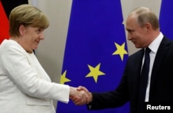 Russian President Vladimir Putin and German Chancellor Angela Merkel shake hands following a joint news conference in the Black Sea resort of Sochi, Russia, May 18, 2018.
