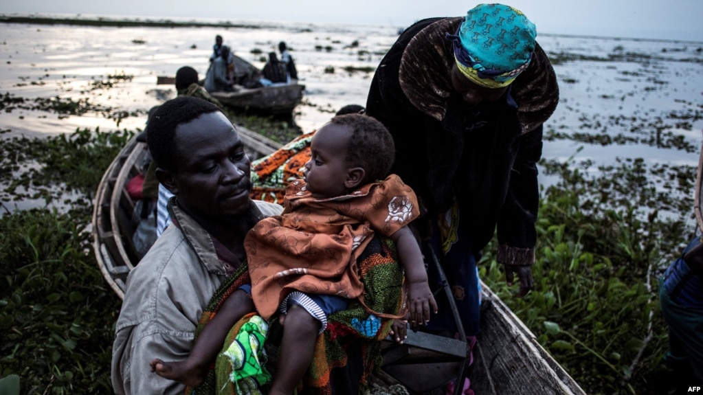 Des congolais embraquent dans des pirogues sur la rive du lac Albert fuient les violences interethniques à Tchomia, Ituri, RDC, 5 mars 2018.