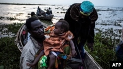 Des congolais embraquent dans des pirogues sur la rive du lac Albert fuient les violences interethniques à Tchomia, Ituri, RDC, 5 mars 2018.