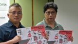 香港記者協會主席陳朗昇(左)與報告主筆楊健興手持香港新聞自由年度報告《破碎的自由》。 （2021年7月15日）