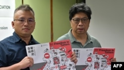 香港记者协会主席陈朗升(左)与报告主笔杨振谦手持香港新闻自由年度报告《破碎的自由》。（2021年7月15日）