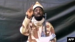 A grab made on July 13, 2013 from a video obtained by AFP shows the leader of the Islamist extremist group Boko Haram Abubakar Shekau, dressed in camouflage and holding an Kalashnikov AK-47. 