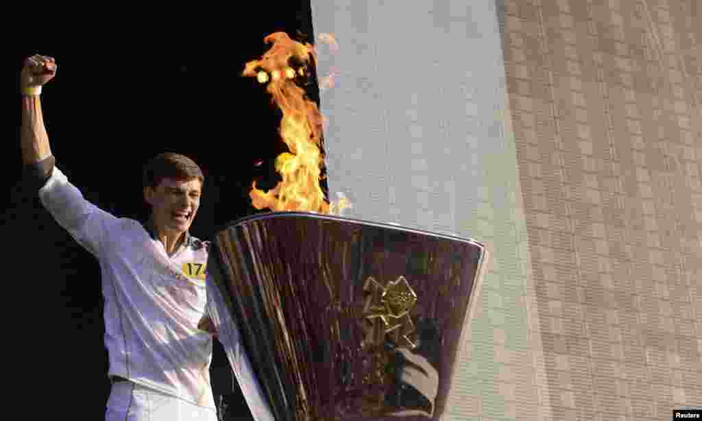 Torchbearer Tyler Rix lights the Olympic Cauldron during the Olympic torch relay celebrations in Hyde Park, London, July 26, 2012. 