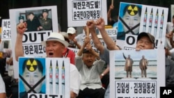South Korean protesters with defaced portraits of North Korean leader Kim Jong Un shout slogans during an anti-North Korean rally in Seoul, Aug. 21, 2015.