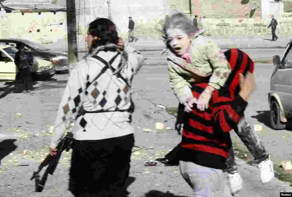 A man carries a wounded girl who survived what activists say was an air strike by forces loyal to Syrian President Bashar al-Assad in Aleppo&#39;s al-Ansari al-Sharqi neighborhood. 