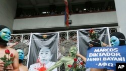 Mahasiswa Universitas Filipina memasang plakat dan berlarian tanpa mengenakan pakaian di kampus mereka sebagai bentuk aksi protes atas pemakaman mantan diktator Filipina, Ferdinand Marcos di Taman Makam Pahlawan, di kota Quezon, Filipina, 25 November 2016 (AP Photo/Bullit Marquez).