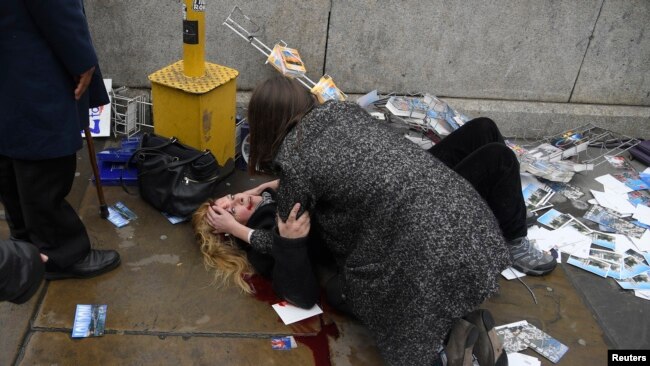 Vestminister Körpüsündə baş vermiş silahlı insident nəticəsində qadın yaralı halda yerdə uzanıb. London, 22 mart, 2017.