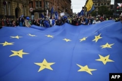 Protestors carry a giant EU flag during an anti-Brexit march on the first day of the Conservative Party annual conference in Manchester on Oct. 1, 2017.