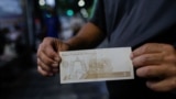 Un hombre muestra un nuevo billete de 5 bolívares, la moneda nacional venezolana, el día en que entra en vigencia su segunda reconversión monetaria en tres años, en Caracas, el 1 de octubre de 2021.