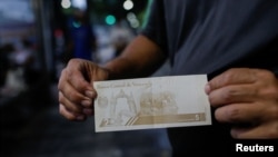 Un hombre muestra un nuevo billete de 5 bolívares el día que el gobierno lanzó la segunda reforma monetaria en tres años al eliminar seis ceros de la moneda bolívar en respuesta a la hiperinflación, en Caracas, Venezuela, el 1 de octubre de 2021.