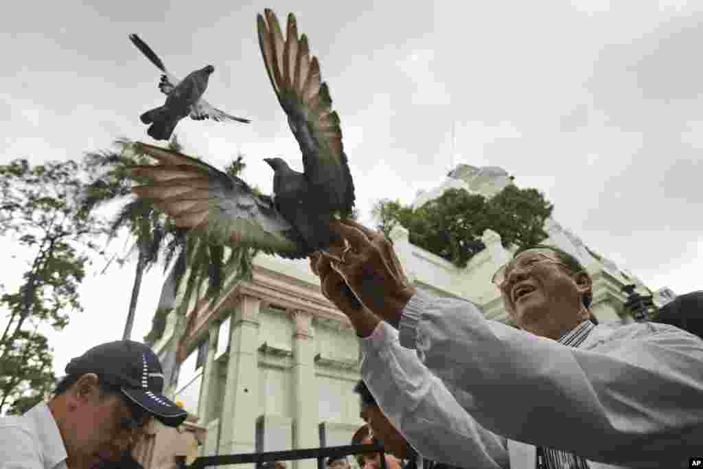 Doves are released for peace at the Erawan Shrine at Rajprasong intersection, the scene of Monday's bombing, in Bangkok, Thailand. Somber horns sounded Friday at the site of the deadly blast as officials joined a multi-religious ceremony for victims of the attack.