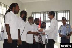 Presiden Joko Widodo (kanan) memberikan pengampunan kepada lima tahanan politik di sebuah rumah tahanan di Jayapura, Papua, 9 Mei 2015. (Foto: Antara via Reuters)