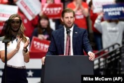 Eric Trump, son of President Donald Trump, speaks during a campaign rally as his wife, Lara watches in Charlotte, N.C., Monday, March 2, 2020. (AP Photo/Mike McCarn)