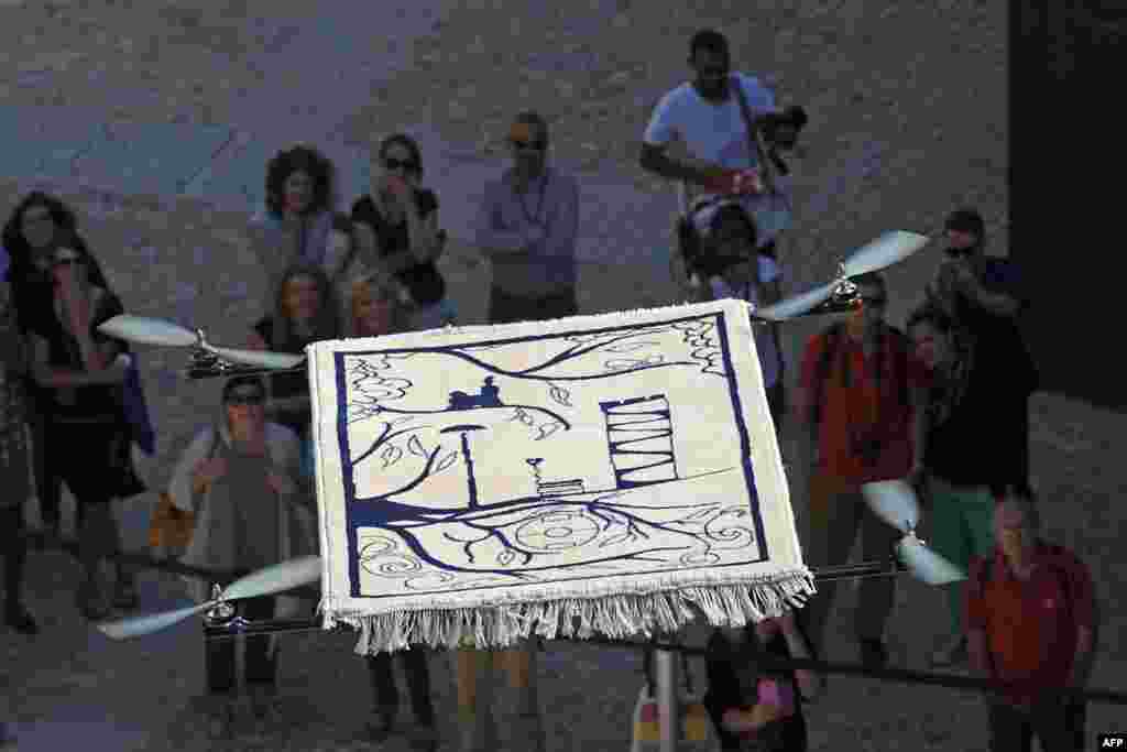 People watch the &quot;Flying carpet&quot;, an artwork created by French artist Moussa Sarr, as it takes off from the Saint Jean fort in Marseille, southern France, as part of &quot;L&#39;artiste dans la cite&quot; (&#39;The Artist in the City&#39;) events organized by the MUCEM, &quot;Musée des Civilisations de l&#39;Europe et la Méditerranée&quot;.