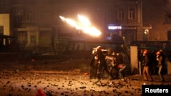 Para pengunjuk rasa pro-Eropa melemparkan bom ke arah polisi anti huru-hara saat terjadi bentrokan di Kyiv (20/1).