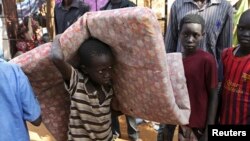 An internally displaced boy carries his belongings inside a United Nations Missions in a compound in Juba, South Sudan, Dec. 19, 2013.