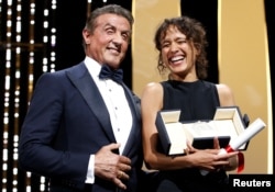 Director Mati Diop, Grand Prix award winner for her film "Atlantics," reacts next to Sylvester Stallone at the 72nd Cannes Film Festival in Cannes, France, May 25, 2019.