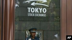 Охранник на входе Токийской фондовой биржи. Япония. 31 мая 2013 г.