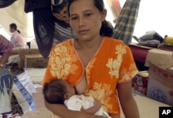 Barunah breastfeeds her 17 days-old baby, Muhammad Rizky in Banda Aceh, Indonesia on Feb. 4, 2005.
